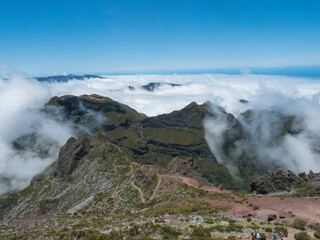 View from Pico Ruivo highest peak in the Madeira, Portugal. Green mountains, misty clouds and and atlantic ocean at Hiking trail PR1.2 from Achada do Teixeira to Pico Ruivo.