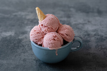 Homemade organic strawberry creamy ice cream in mug made with coconut yogurt, fresh strawberry and...