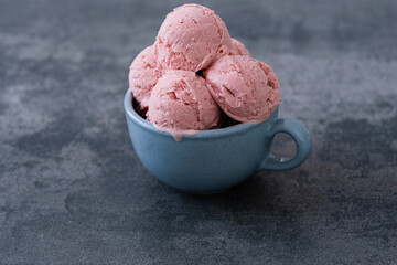 Creamy vegan ice cream in mug made with coconut yogurt, fresh strawberry. Summer seasonal cold sweet healthy dessert.