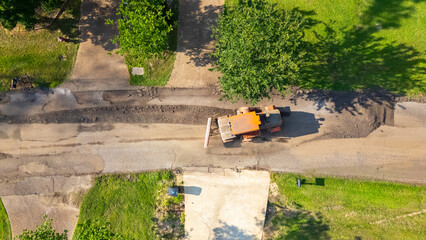 Construction vehicle preparing road for new layer of asphalt