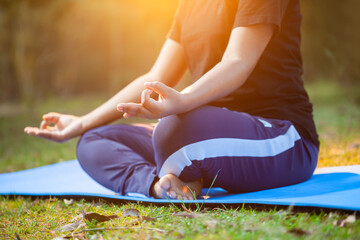 women doing gyana mudra during sunrise at outdoor, cropped view