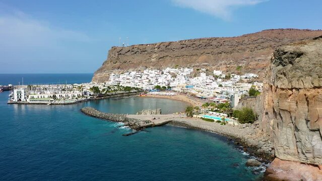 Puerto de Mogan with the beach in Gran Canaria, Spain. Favorite vacation place for tourists and locals on island. Harbor in Puerto de Mogan and Playa Mogan on Grand Canary Island, Spain.