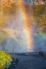 Vivid rainbow near a waterfall. Nature, colors, light effects at sunset.