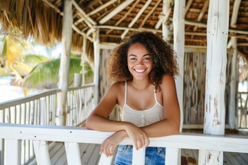 A woman with a smile on her face leaning casually on a white railing