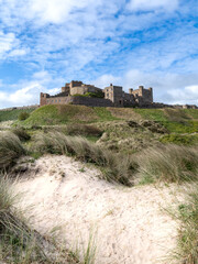 Vertical landscape of Bamburgh Castle and sand dunes in Northumberland