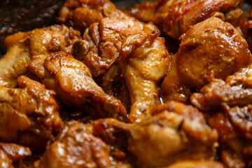 chicken breast pieces in a frying pan stewed in sauce and spices