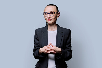 Portrait of thinking serious confident business woman , on grey studio background