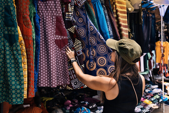Woman browsing colorful fabrics at a street market