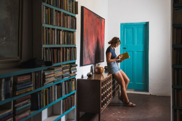 Young woman reading a book in a cozy room