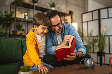 Father and son read a book and have fun while spend time together