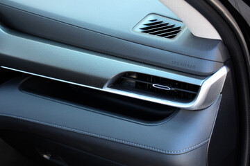 Modern SUV air vents close-up grille. Air ventilation grille with power regulator. Modern Car air conditioner, interior of a new modern SUV. Passenger airbag. Front airbag.