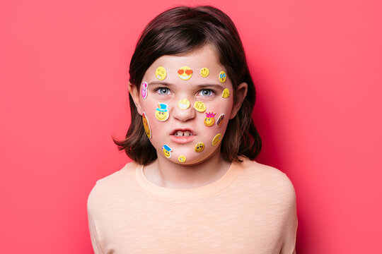 Naklejki Schoolgirl with emoji stickers on her face