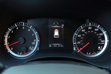 Modern car odometer. Premium car speedometer. Modern car dashboard. Close up of speedometer dial with warning lights on a car.