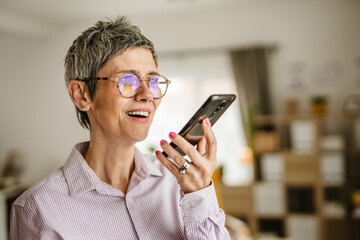 Portrait of mature woman stand talk on phone or left a voice message