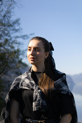 a pensive dreamy young woman sails on a ship on an alpine lake against the backdrop of mountains.beautiful brunette is sad and dreams, enjoying nature.