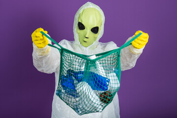 Alien in a protective suit holding a net filled with plastic waste, symbolizing a universal concern for environmental cleanup.