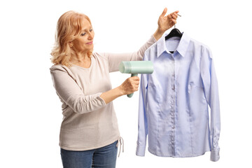 Woman holding a shirt on a hanger and using a steam iron