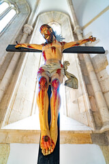 image against sting of the figure of Jesus Christ crucified and bloodied in suffering with blood...