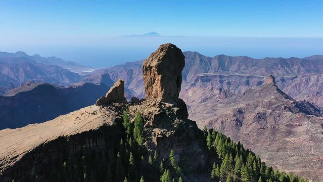 Roque Nublo and Pico de Teide in the background on Gran Canaria Island, Spain. Panoramic view of Roque Nublo sacred mountain, Roque Nublo Rural Park, Gran Canary, Canary Islands, Spain.