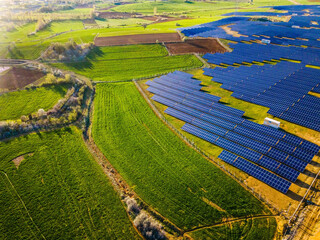 Sunset Glow of Green Energy: 4K UHD image of Solar Panel Power Plant in Beautiful Green Fields -...