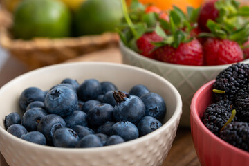 Blueberries, strawberries and black mulberries in bowls