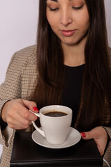 Young woman with a cup of coffee and a diary. Coffee break during working hours