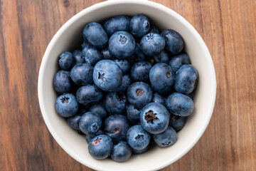 Top view of blueberries in bowl on wooden table