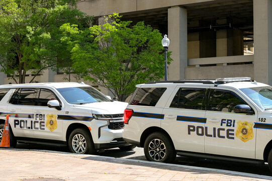 Washington DC, USA - 30 April 2024: Police patrol cars used by the FBI parked on a street outside the J Edgar Hoover headquarters building in downtown Washington DC
