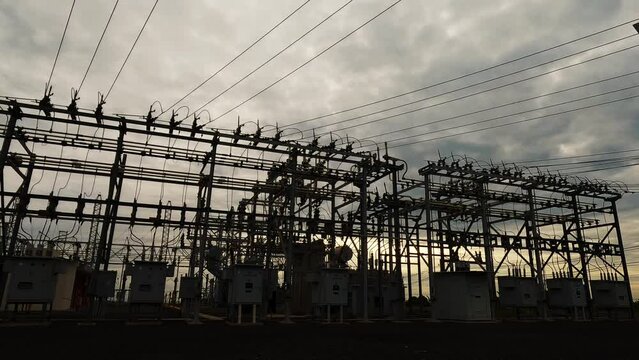 Silhouette of substation for the distribution of electric power with in Brazil, with time lapse of clouds and sundown background