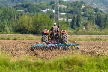A farmer using a tractor to plough a field