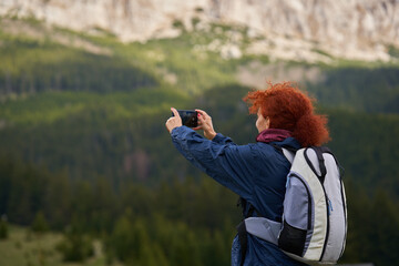 Woman hiker shooting landscapes with her phone