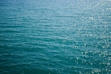 The surface of the sea water. Background texture of a calm deep blue ocean with ripples