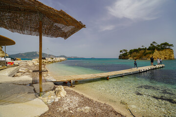 Caméo island panorama from Agios Sostis harbour with a parasol