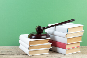 Law concept - Open law book with a wooden judges gavel on table in a courtroom or law enforcement...