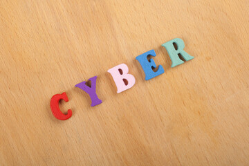 CYBER word on wooden background composed from colorful abc alphabet block wooden letters, copy...