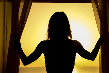 Silhouette of a girl on a loggia balcony background. Happy woman on vacation traveling.