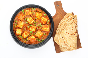 Matar Paneer curry recipe made using cottage cheese, green peas, served in a bowl. selective focus Delhi, Rajasthan India. Top view Indian veg curry on blue background. side dish Roti, Chapati, naan.