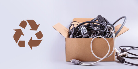 Box filled with damaged electronic gadgets and wires, illustrating the concept of green disposal...