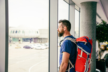 handsome man with backpack waiting in airport