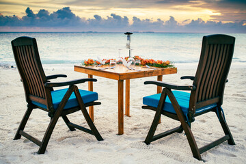 romantic dinner table setting on sunset beach