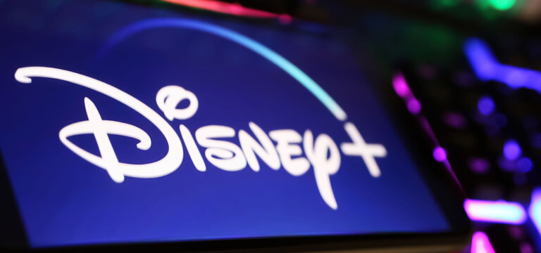 Viersen, Germany - May 1. 2024: Closeup of smartphone with logo lettering of Disney Plus streaming service channel  on computer keyboard