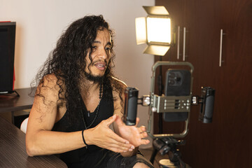 Social Media Content Creation. A long-haired content creator immersed in his studio, recording...