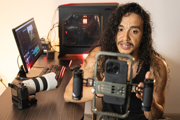Multimedia Equipment Management. A long-haired content creator immersed in his studio, recording...