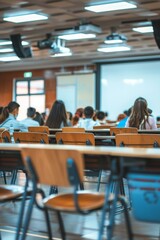 Obraz premium Students in lecture hall listening attentively, modern educational environment, suitable for educational themes.