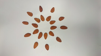 Almond (badaam) with Artistic arrangement isolated on white background - health care concept