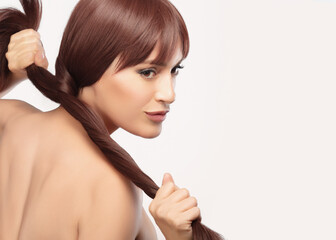 Beautiful woman with healthy long hair in a creative pose showing the strength of her long thick...