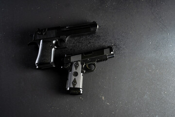 Two guns on black table, criminal concept