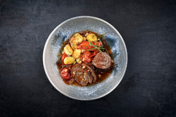 Traditional slow cooked German wagyu beef roulades with vegetable and gnocchi served in spicy red...