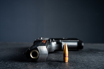 gun and bullet on black table, criminal concept