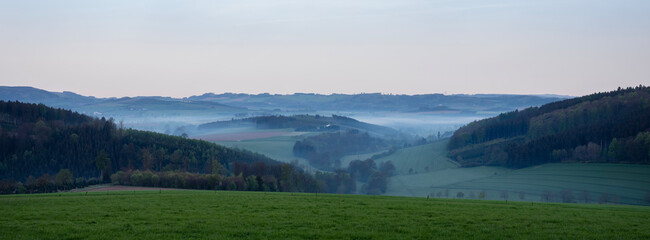 early morning landscape with mist in german sauerland